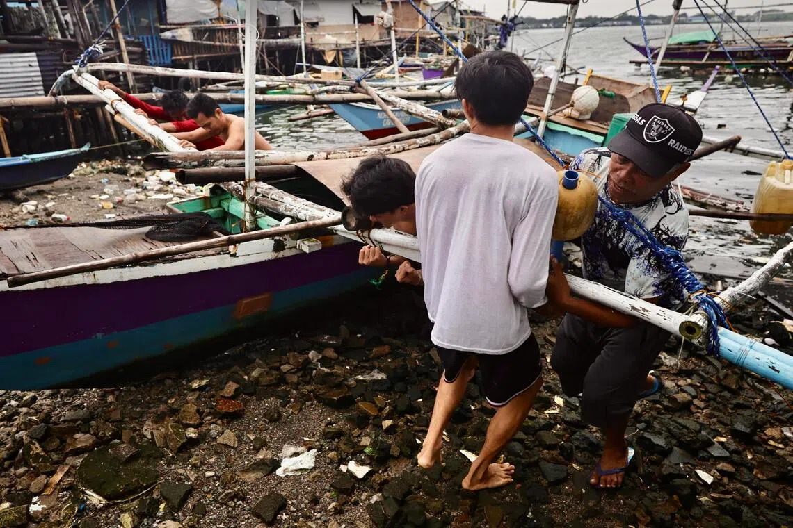 Fishermen secure a boat in anticipation of an approaching storm in Cavite city, south of the capital Manila.
