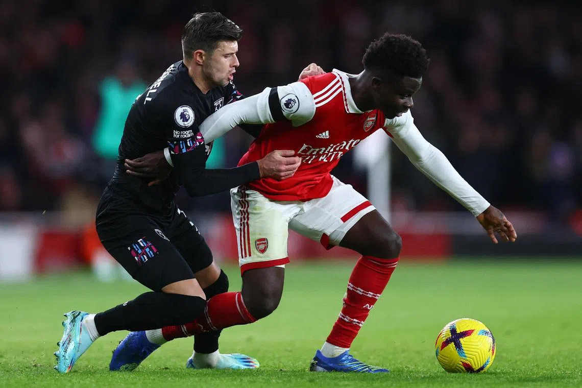 West Ham United's Aaron Cresswell keeping close watch on Arsenal's Bukayo Saka.