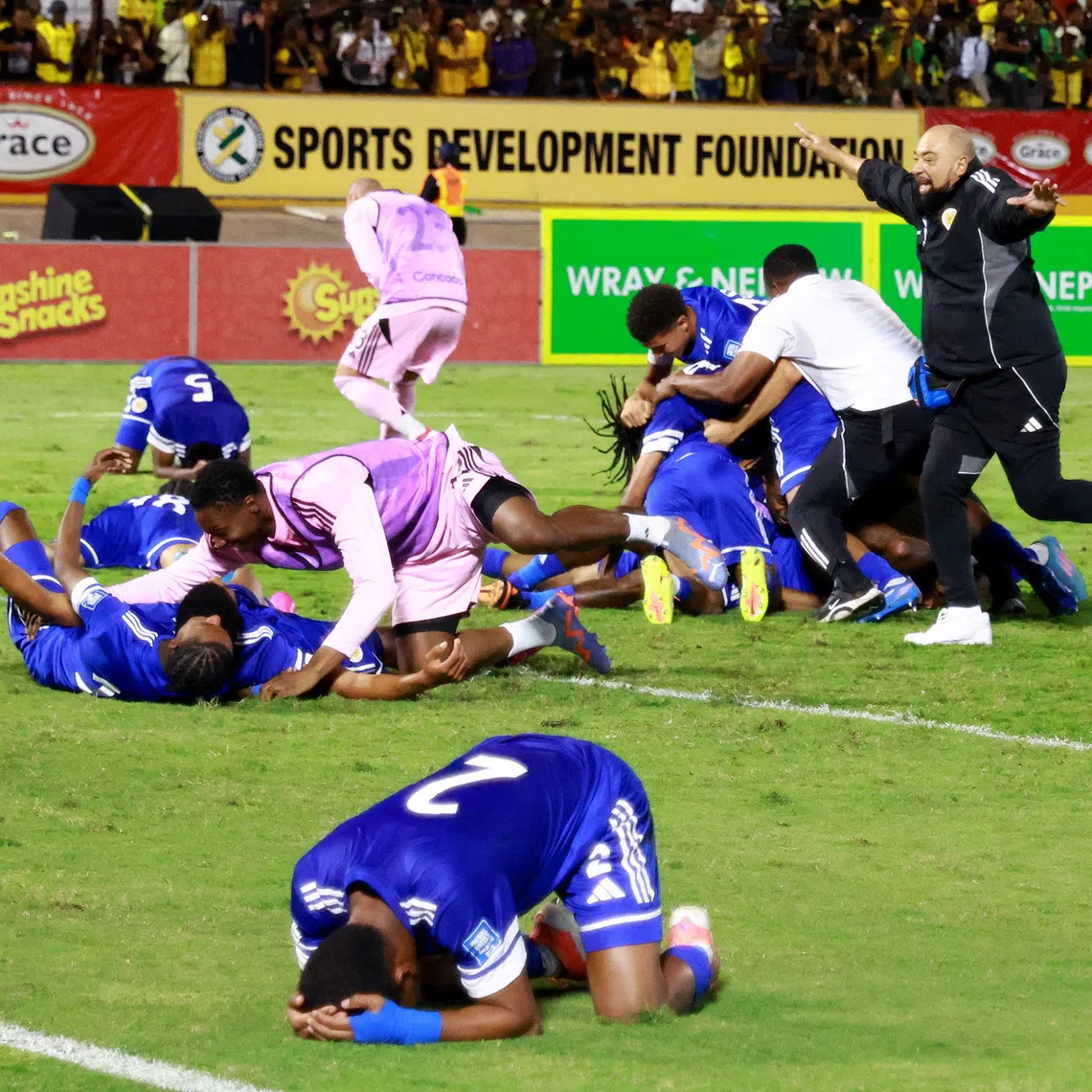 Soccer Football - FIFA World Cup - CONCACAF Qualifiers - Group B - Jamaica v Curacao - National Stadium Independence Park, Kingston, Jamaica - November 18, 2025 Curacao coach Dean Gorre and players celebrate after they qualify for the World Cup REUTERS/Gilbert Bellamy