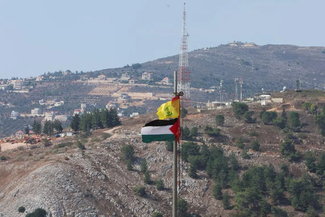 Palestinian and Hezbollah flags flutter in Khiam, near the border with Israel, in southern Lebanon October 9, 2023. REUTERS/Aziz Taher/File Photo