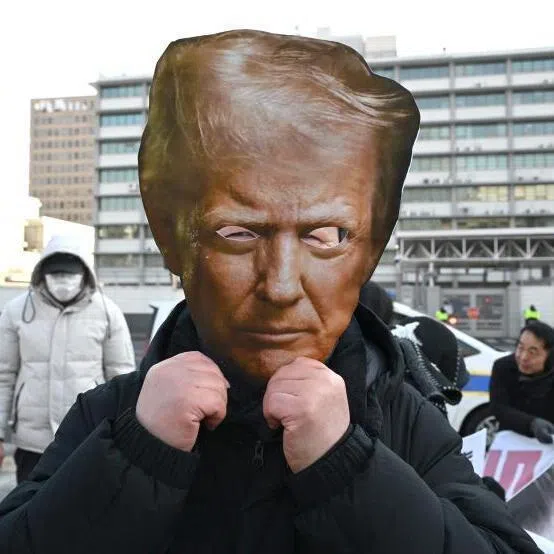 A protester wearing a mask of Donald Trump during a rally in Seoul on Jan 27 condemning the abrupt raising of tariffs -- a favourite trade weapon of the US president.