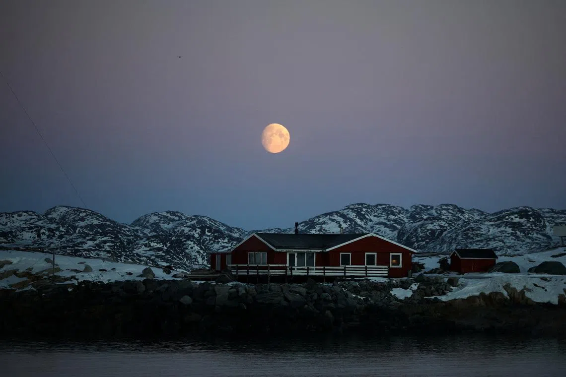 The moon rises over a house in Nuuk, Greenland, January 30, 2026. REUTERS/Stoyan Nenov