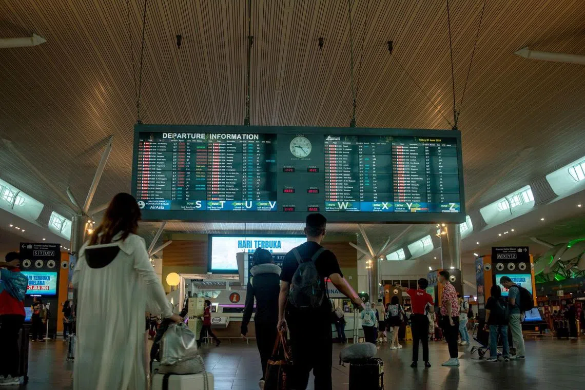 An overhead flight information display in the departure hall of the Kuala Lumpur International Airport 2 (KLIA 2) in Sepang, Selangor, Malaysia, on Friday, June 21, 2024. There’s no end in sight to the high airfares that are a mainstay of the world’s post-pandemic travel boom, according to Asia’s biggest low-cost carrier. Photographer: KG Krishnan/Bloomberg