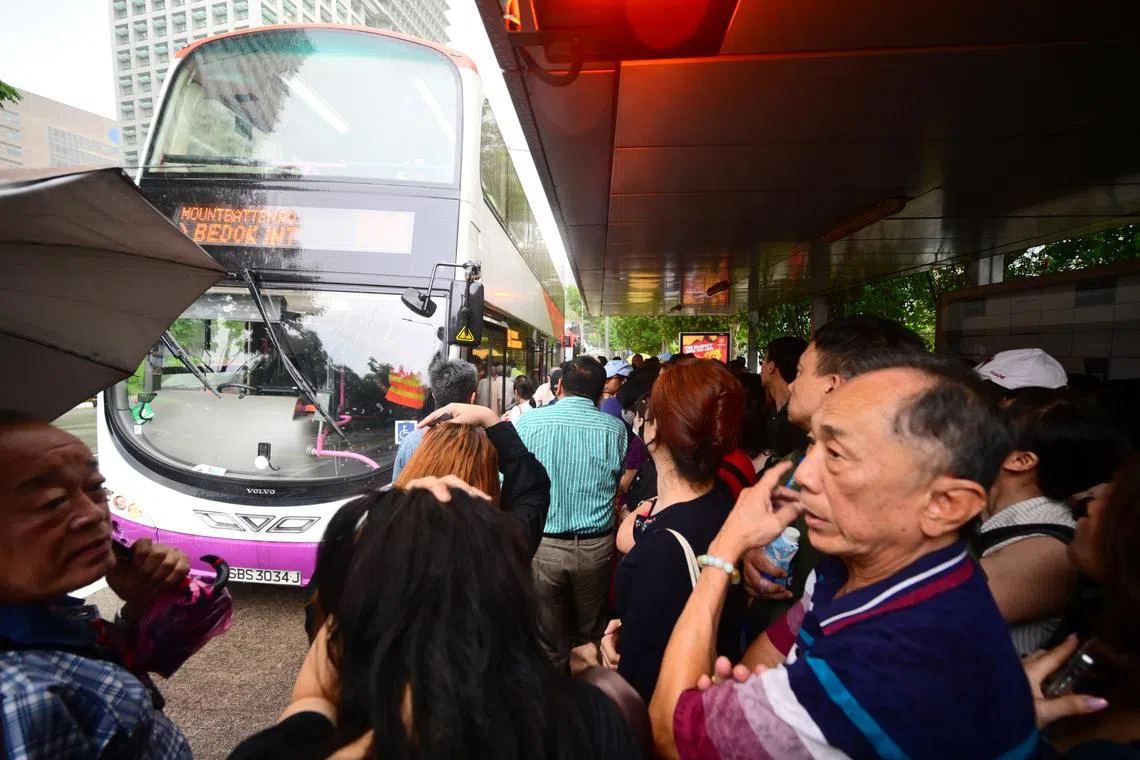 Passengers caught in the rain as they rush to board buses at 11:30am at Buona Vista Station, on Sept 25, 2024. 