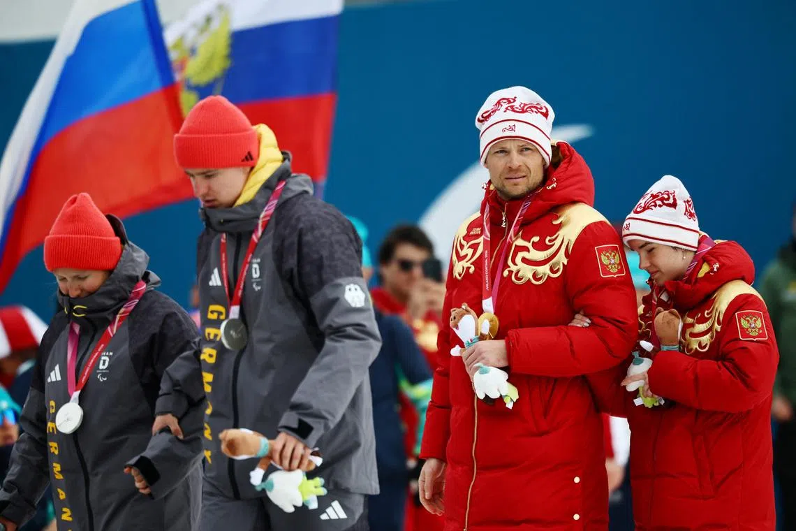 Milano Cortina 2026 Paralympics - Para Cross-Country Skiing - Women's Sprint Classic Vision Impaired Victory Ceremony - Tesero Cross-Country Skiing Stadium, Lago, Italy - March 10, 2026. Gold medallists Anastasiia Bagiian of Russia and guide Sergei Siniakin of Russia and silver medallists Linn Kazmaier of Germany and guide Florian Baumann of Germany exit the podium after the victory ceremony REUTERS/Sarah Meyssonnier
