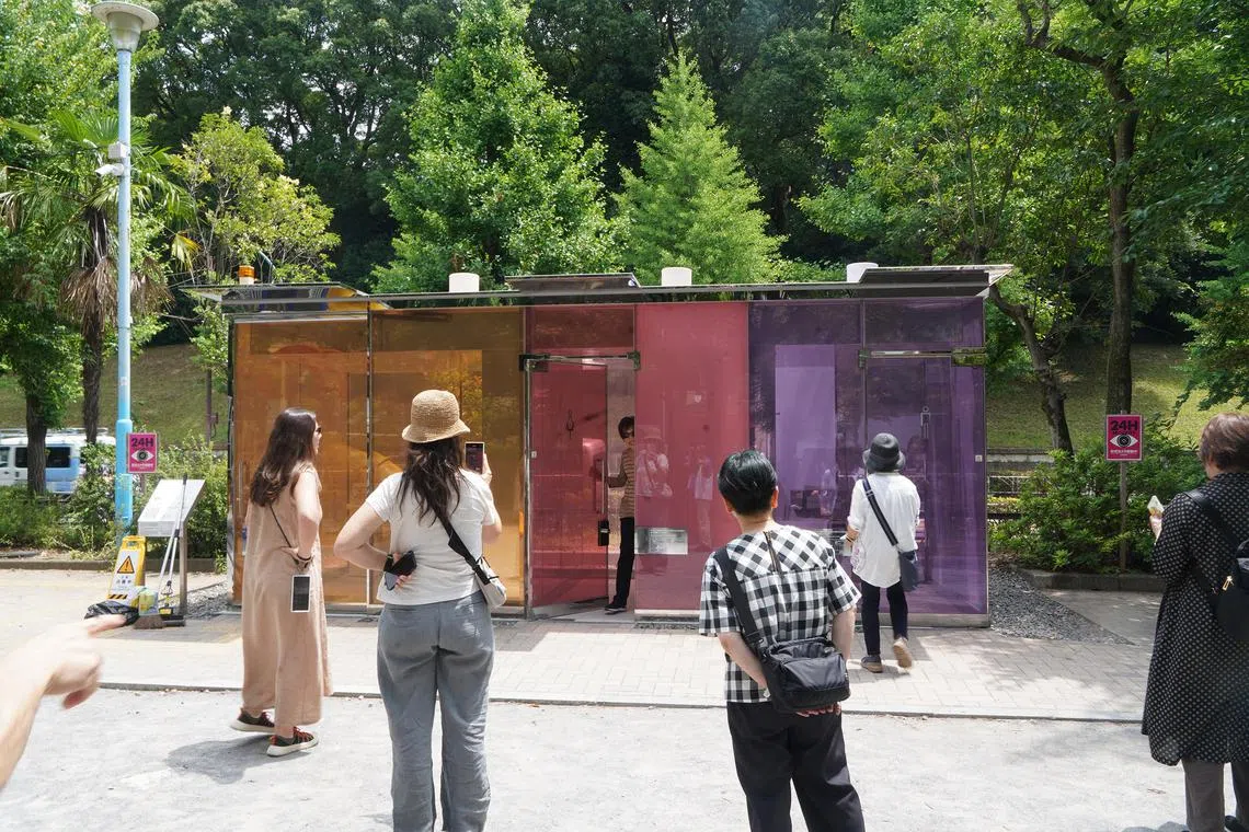 Tourists gather around one of two toilets, known for their transparent walls that turn opaque when the door is locked. These were designed by architect Shigeru Ban for The Tokyo Toilet Project, in which a total of 17 public toilets across Tokyo's Shibuya Ward were redesigned into stylish barrier-free spaces.
