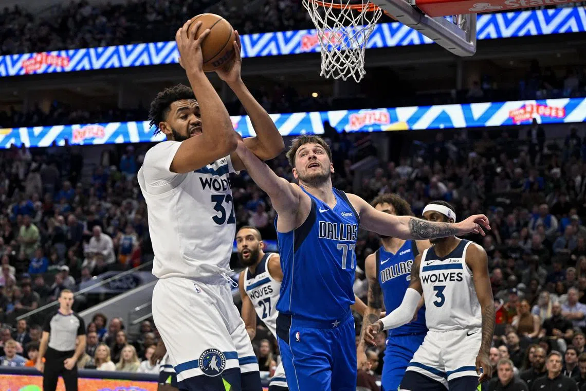 Minnesota Timberwolves centre Karl-Anthony Towns grabs a rebound in front of Dallas Mavericks guard Luka Doncic during the second half at the American Airlines Centre.