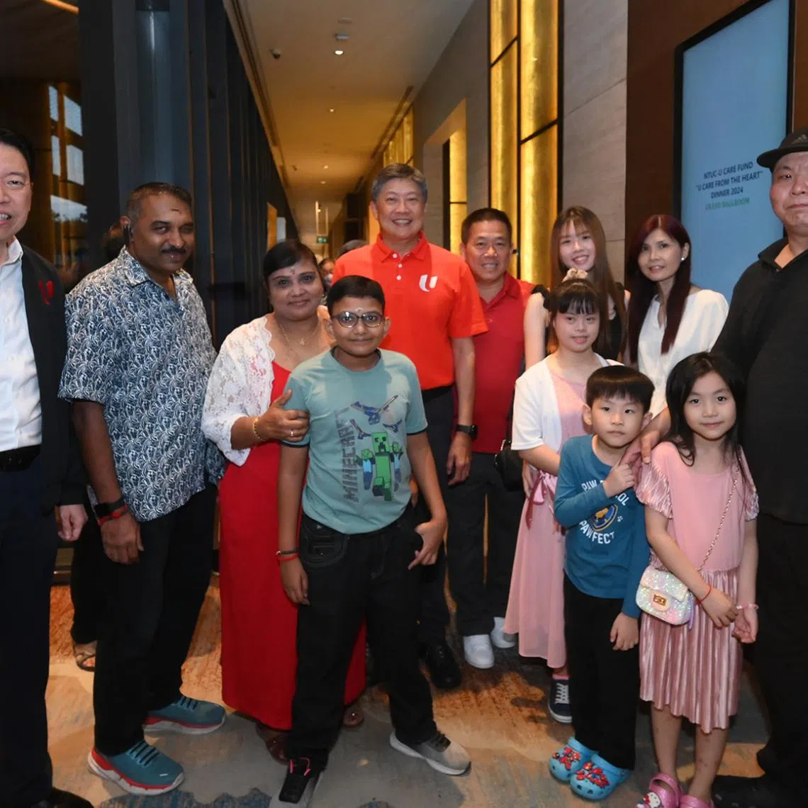 NTUC secretary-general Ng Chee Meng (fifth from left) and NTUC assistant secretary-general Melvin Yong (left) with beneficiaries.