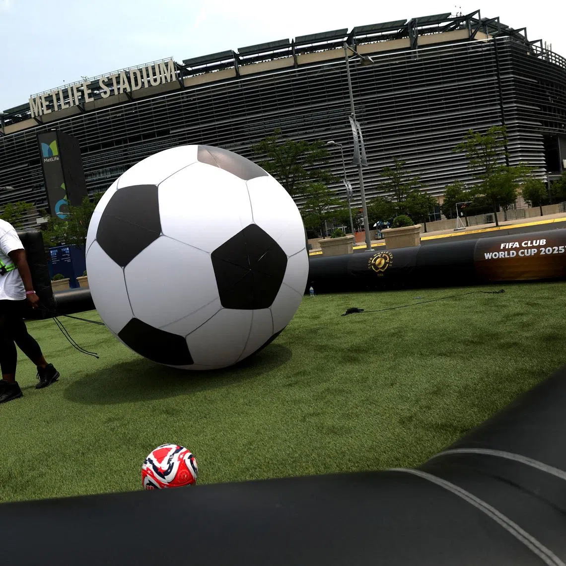 FILE PHOTO: Soccer Football - Club World Cup - Previews - MetLife Stadium, East Rutherford, New Jersey, U.S. - June 13, 2025   General view of a member of staff with a giant ball on a pitch outside the stadium ahead of the Club World Cup REUTERS/Susana Vera/File Photo