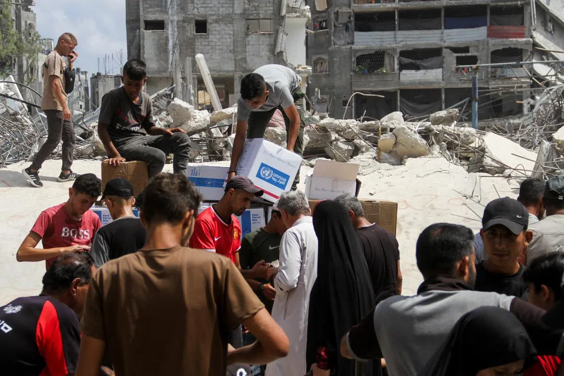Palestinians gather to receive aid, including food supplies provided by World Food Program (WFP), outside a United Nations distribution center, amid the Israel-Hamas conflict, in Jabalia in the northern Gaza Strip, August 24, 2024. REUTERS/Mahmoud Issa/File Photo