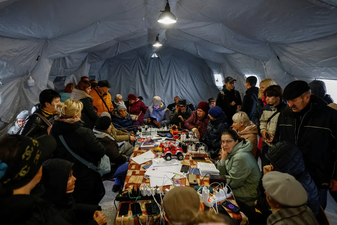 People shelter inside an invincibility centre, where they can use Internet connection, charge their devices and warm up, amid water and electricity supply outage, after critical infrastructure was hit during Russian drone attack, in Chernihiv, Ukraine October 21, 2025. REUTERS/Maksym Kishka