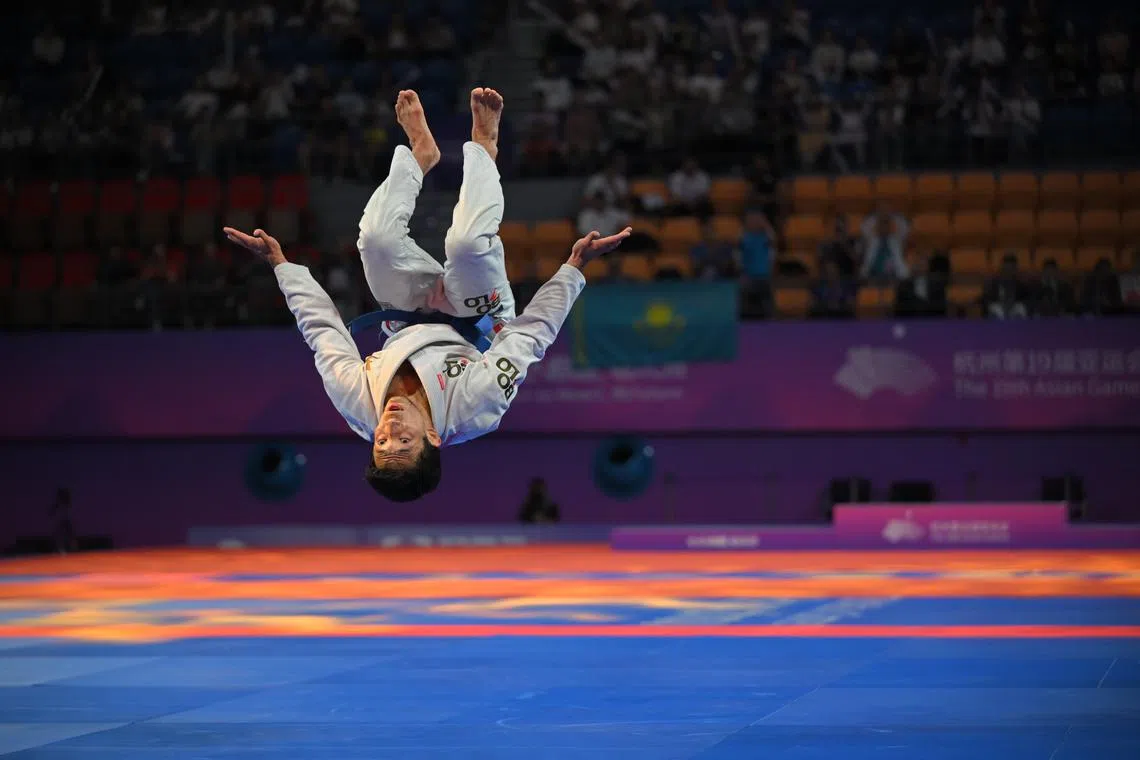 Mansur Khabibulla of Kazakhstan somersaults after beating Marc Alexander Lim of the Philippines during the Men’s Ju Jitsu 62kg bronze medal match at the Xiaoshan Linpu Gymnasium on Oct 5.