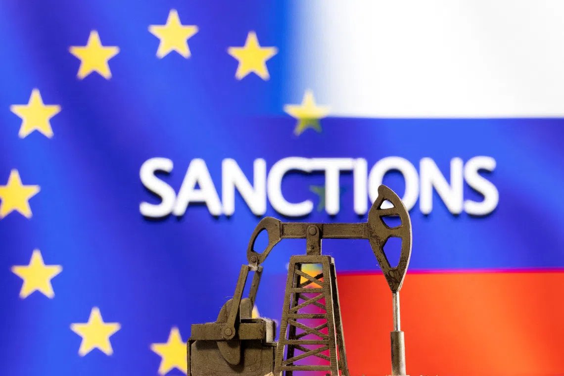 A model of a pump jack is seen in front of the displayed word \"Sanctions\",  EU and Russia flag colours in this illustration taken March 8, 2022. REUTERS/Dado Ruvic/Illustration