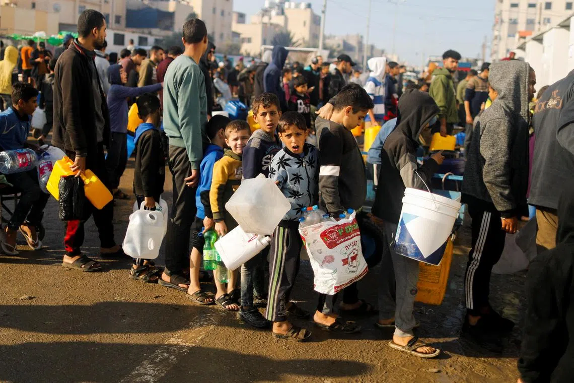 Palestinian children queue as they wait to collect drinking water, amid shortages of drinking water, in Rafah, southern Gaza Strip, on Jan 4.