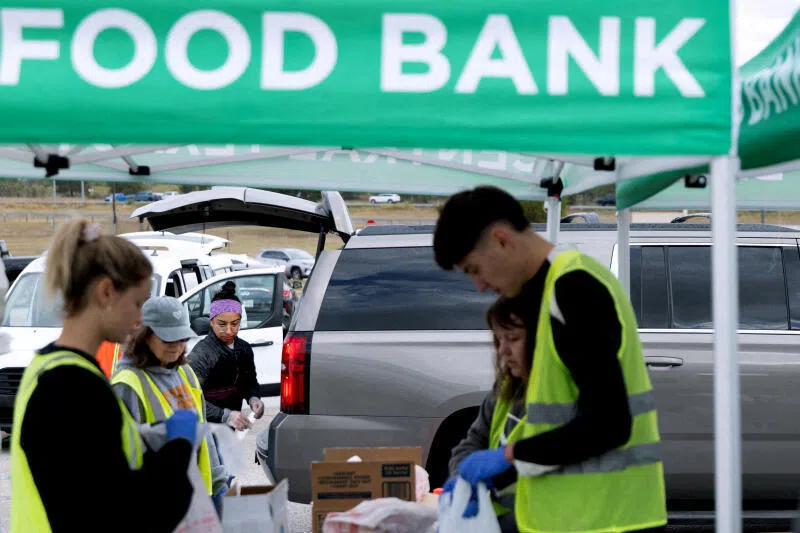 Volunteers place food items in vehicles during a mobile food distribution at Cedar Creek High School in Cedar Creek, Texas, on Nov 1.