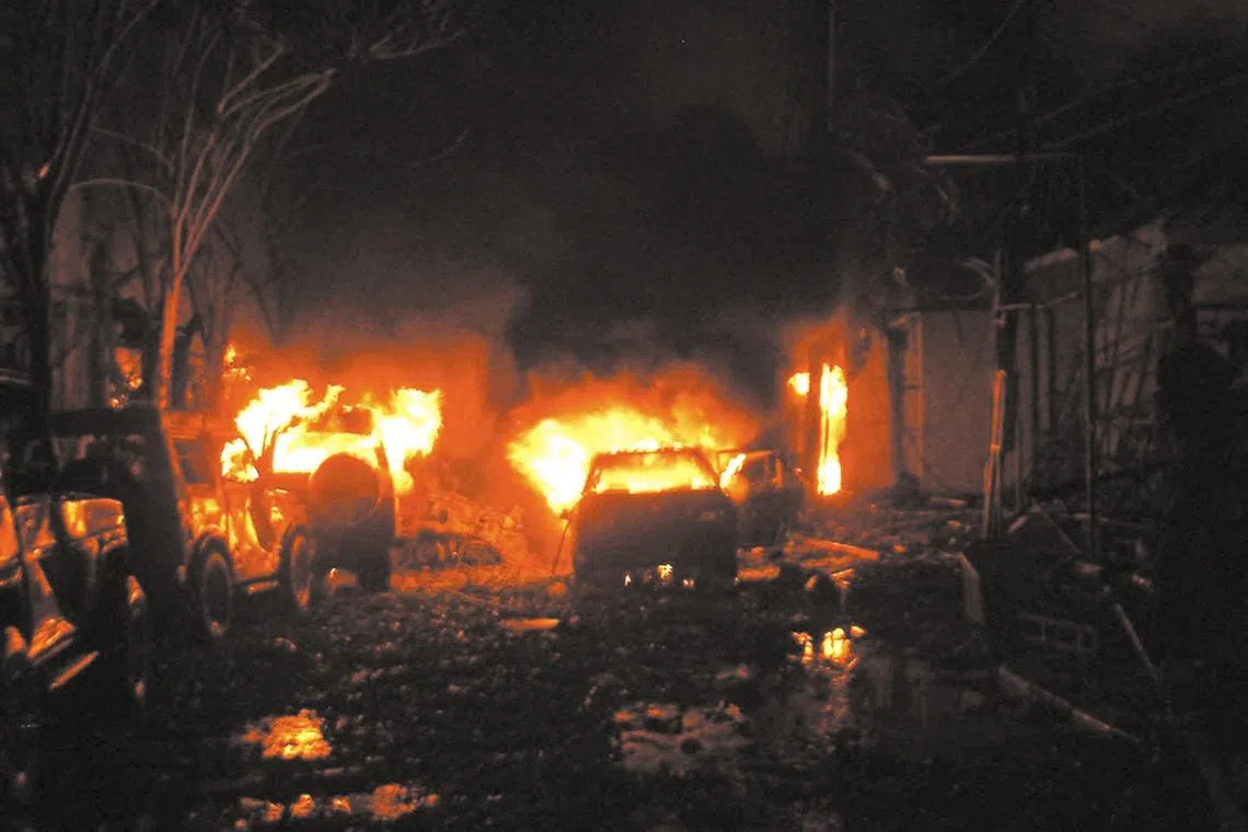 Buildings and cars are on fire after a bomb blast in tourist site of Kuta, Bali 13 October 2002.  At least 53 people including 10 foreigners, were killed when a bomb exploded in a popular nightclub on the Indonesian resort island of Bali.  AFP PHOTO/ DARMA (Photo by DARMA / AFP)