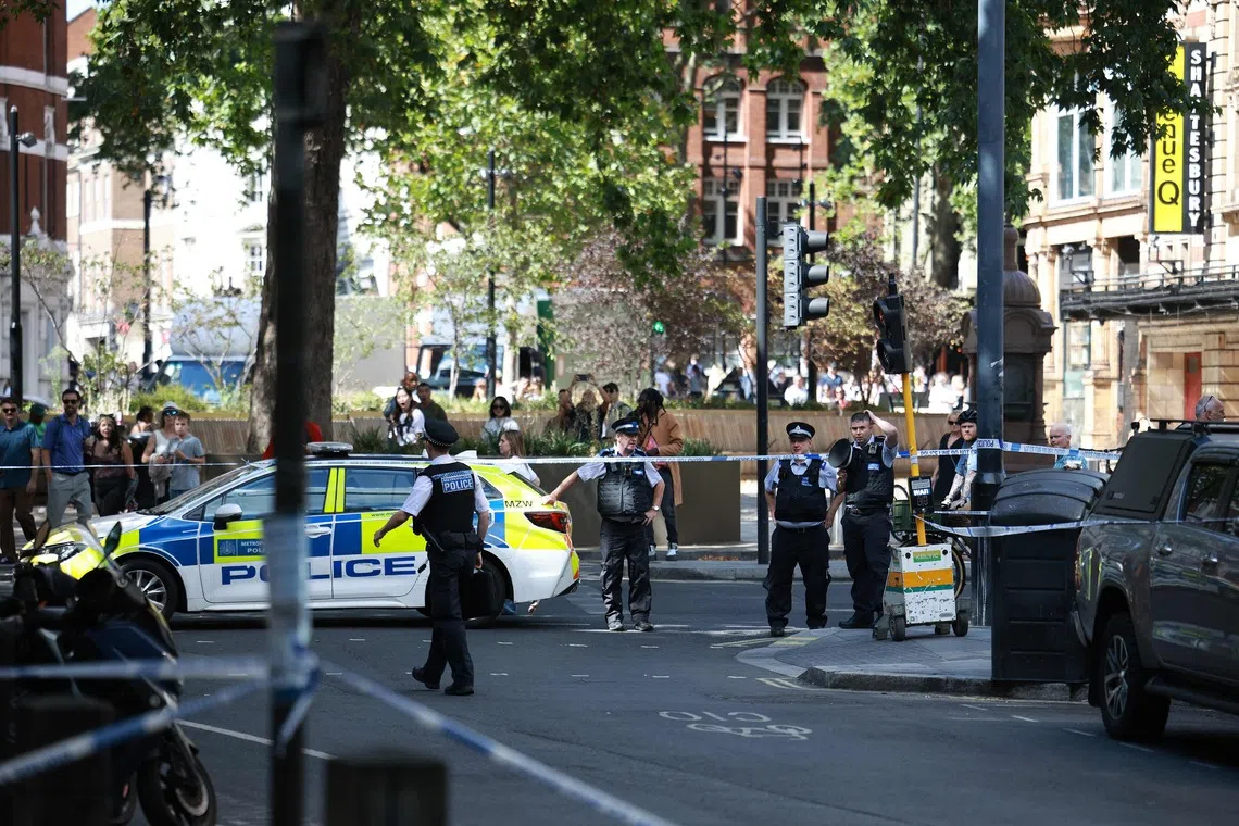 Police Officers stand at a cordon near the Shaftesbury Theatre, pictured from Endell Road in Covent Garden, central London on August 5. A woman was arrested after four men were stabbed in Covent Garden, a busy area of central London popular with tourists, the Metropolitan Police said