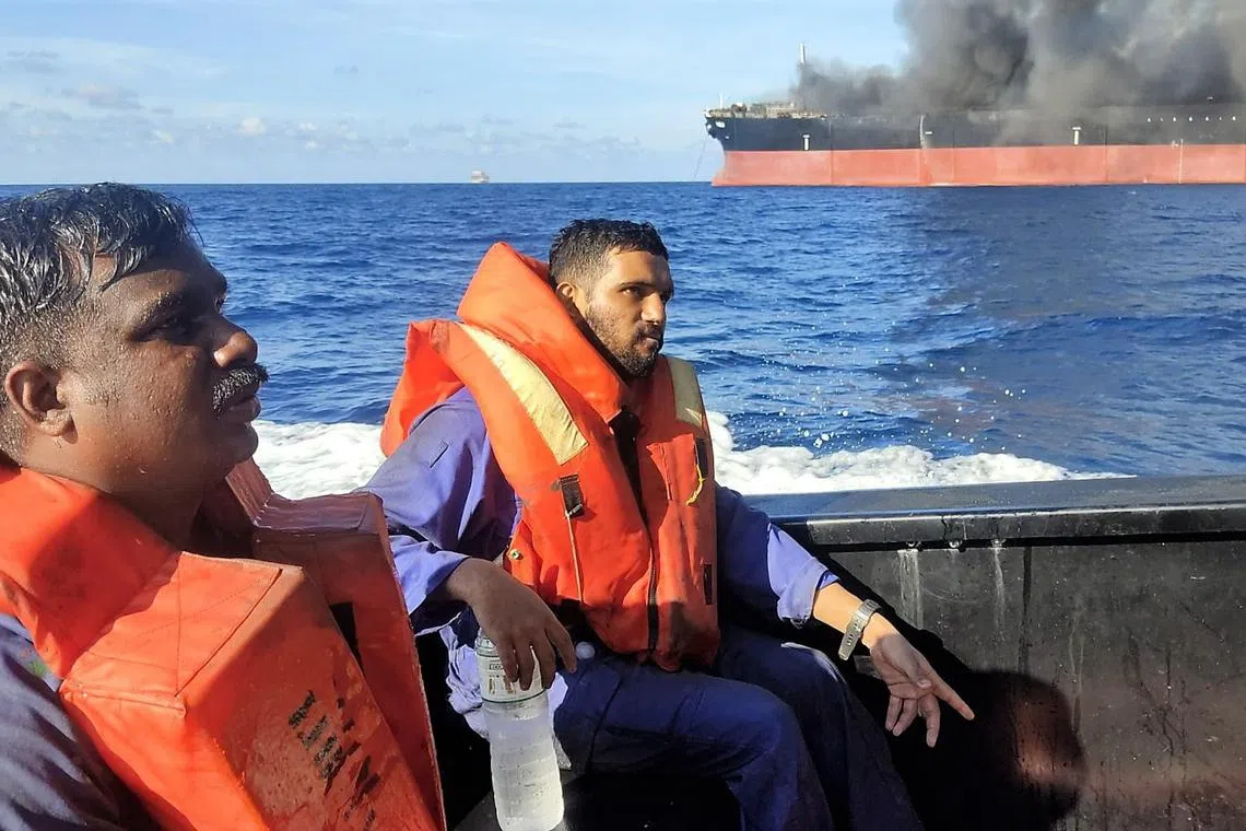 Crew of a Gabon-flagged tanker being rescued by the Malaysian Maritime Enforcement Agency after the vessel caught fire off Malaysia's southern coast on May 2, 2023. Twenty-five crew members were rescued by several ships, and search operations are under way for three missing men. The tanker was heading for Singapore from China when it caught fire. 