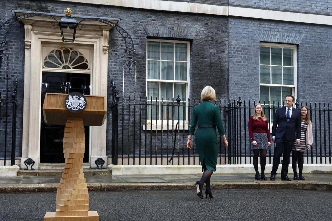 Former British PM Liz Truss walking towards her husband and daughters after announcing her resignation on Oct 25.
