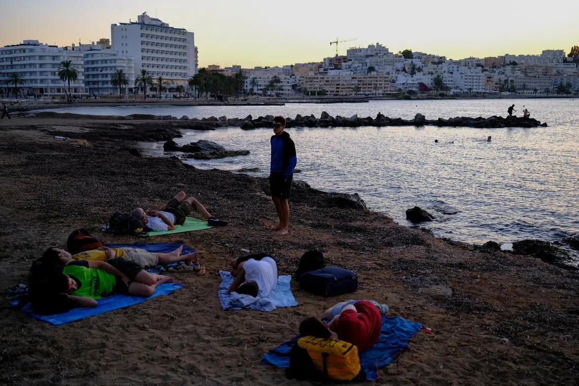 Tourists sleep on Figueretas beach during sunrise in Ibiza, Spain, August 31, 2025. Ibiza received 3.28 million tourists in 2024, 76% from outside Spain, while the island's resident population reached a record 161,485, with nearly 1000 people who resorted to living in makeshift settlements. \"As long as tourists keep coming, there'll be people willing to live in precarious conditions to be employed,\" said Jonathan Ariza, 25, a mechanic and construction worker from Colombia. REUTERS/Nacho Doce