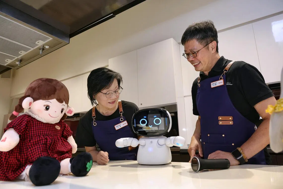 SUSS associate professor Kelvin Tan (right) explaining the features of a robot to Kampong Chai Chee resident Emily Choo at the Care Tech Cafe at Heartbeat@Bedok on July 31.