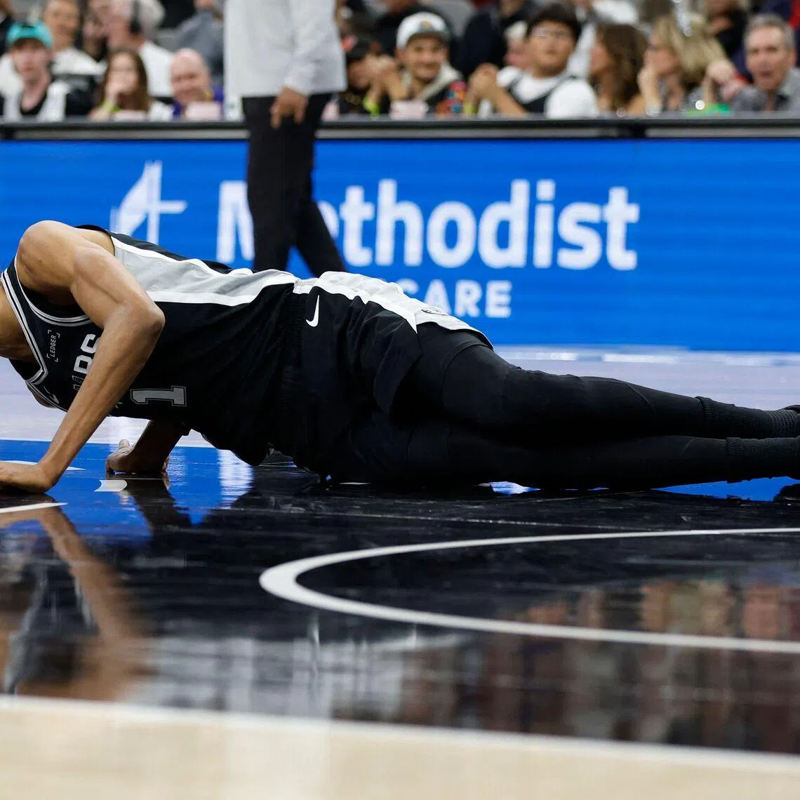 Victor Wembanyama lies on the court in the second half against the New York Knicks at Frost Bank Center.
