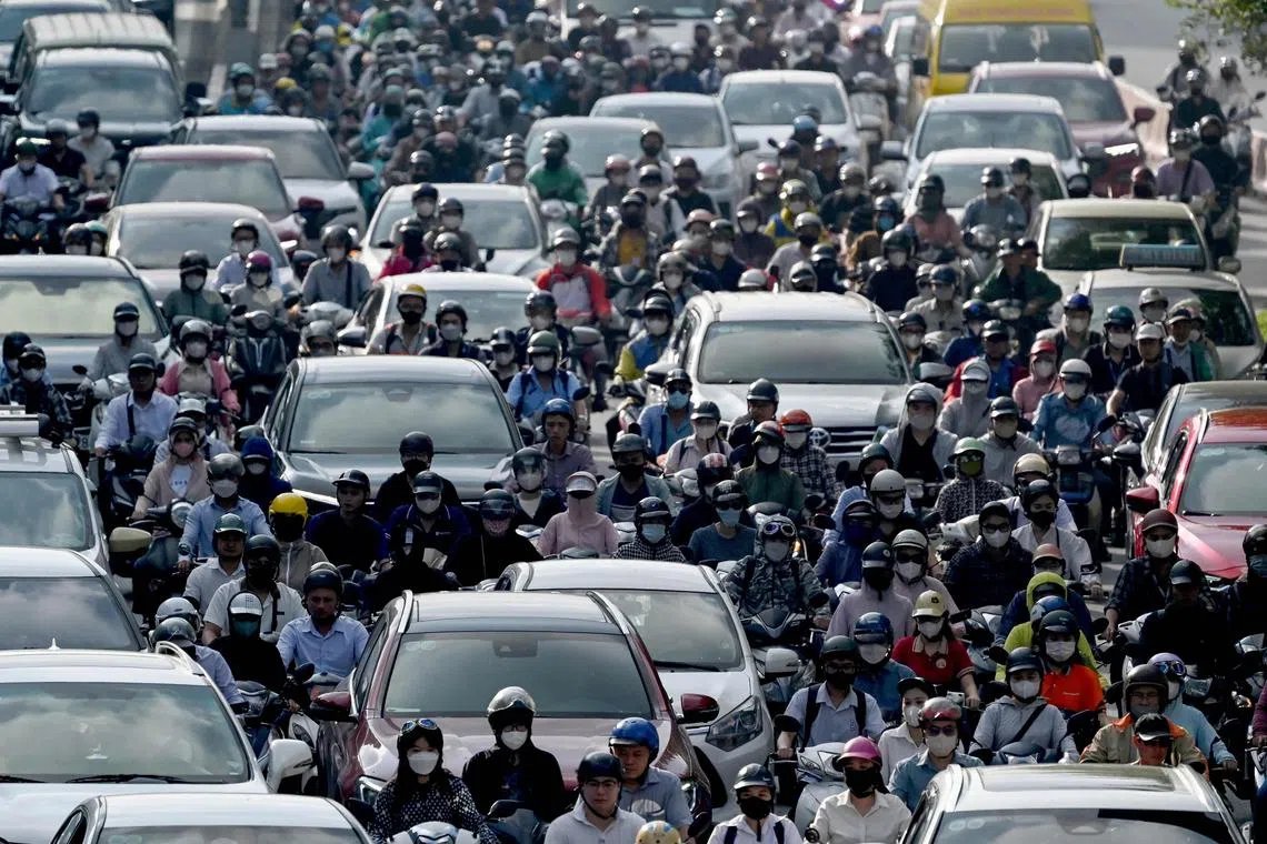 This photo taken on July 17, 2025 shows motorbikes and other vehicles being driven in heavy traffic in Hanoi. Vietnam's plan to bar gas-guzzling motorbikes from central Hanoi may clear the air of the smog-smothered capital, but riders fear paying a high toll for the capital's green transition. (Photo by Nhac NGUYEN / AFP) / To go with 'VIETNAM-TRANSPORT-ENVIRONMENT,FOCUS' by Tran Thi Minh Ha