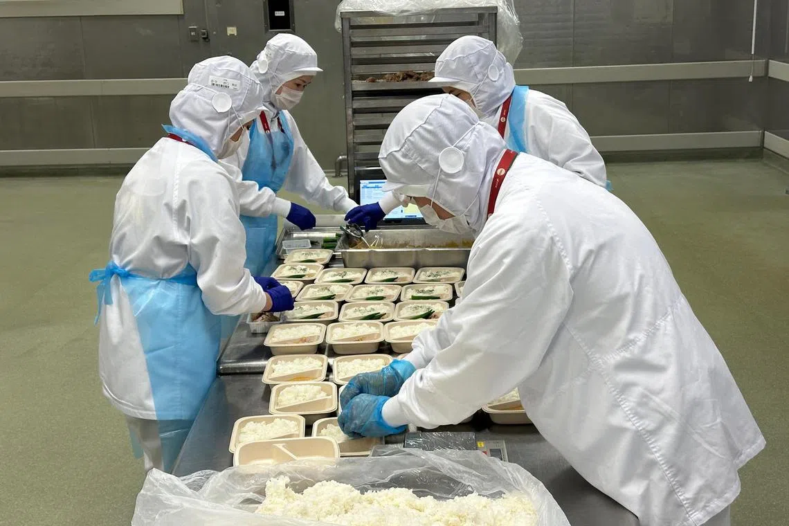 mysats23 - Workers prepare meals at the SATS-TFK kitchen in Tokyo's Narita Airport, Japan.