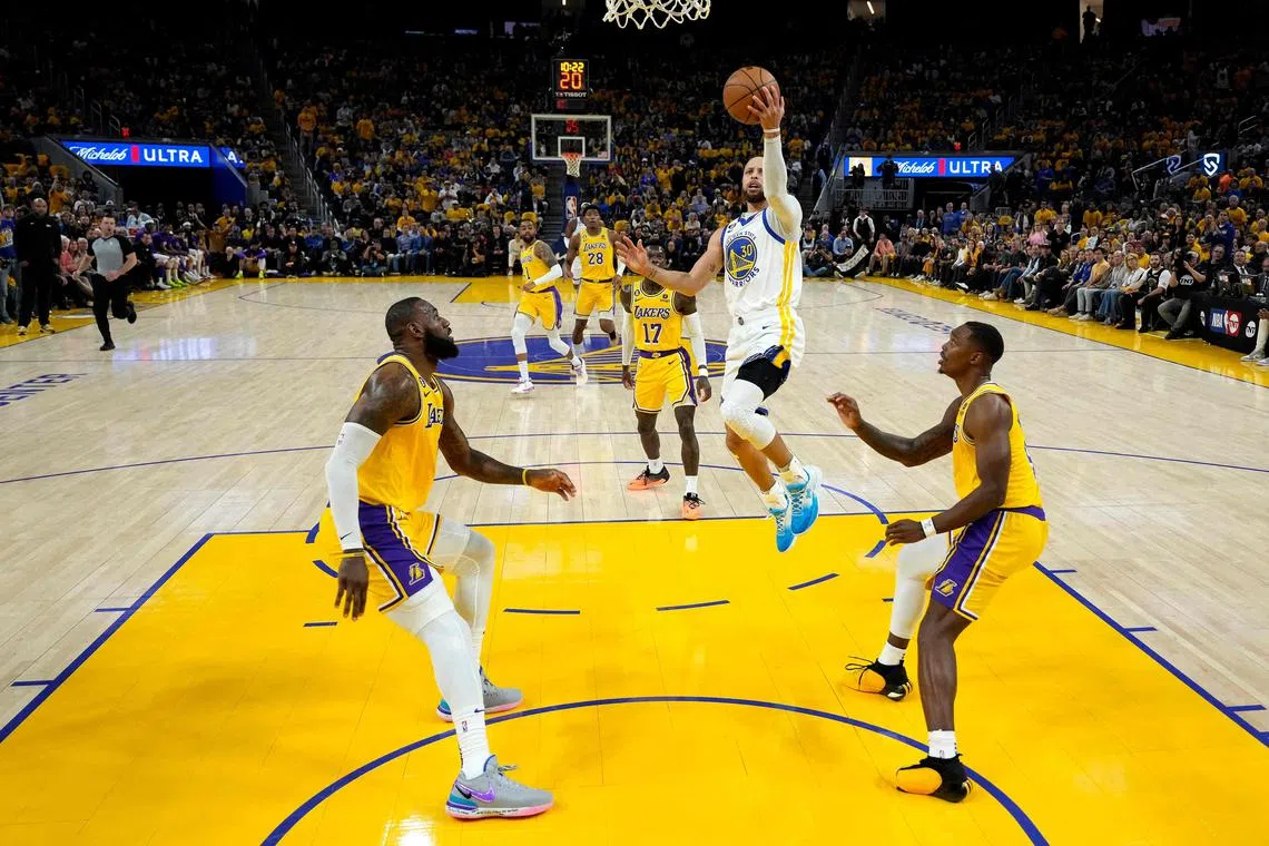 Stephen Curry (centre) of the Golden State Warriors driving to the basket against LeBron James (left) and Lonnie Walker during the second quarter in Game 5 of the Western Conference semi-finals. 