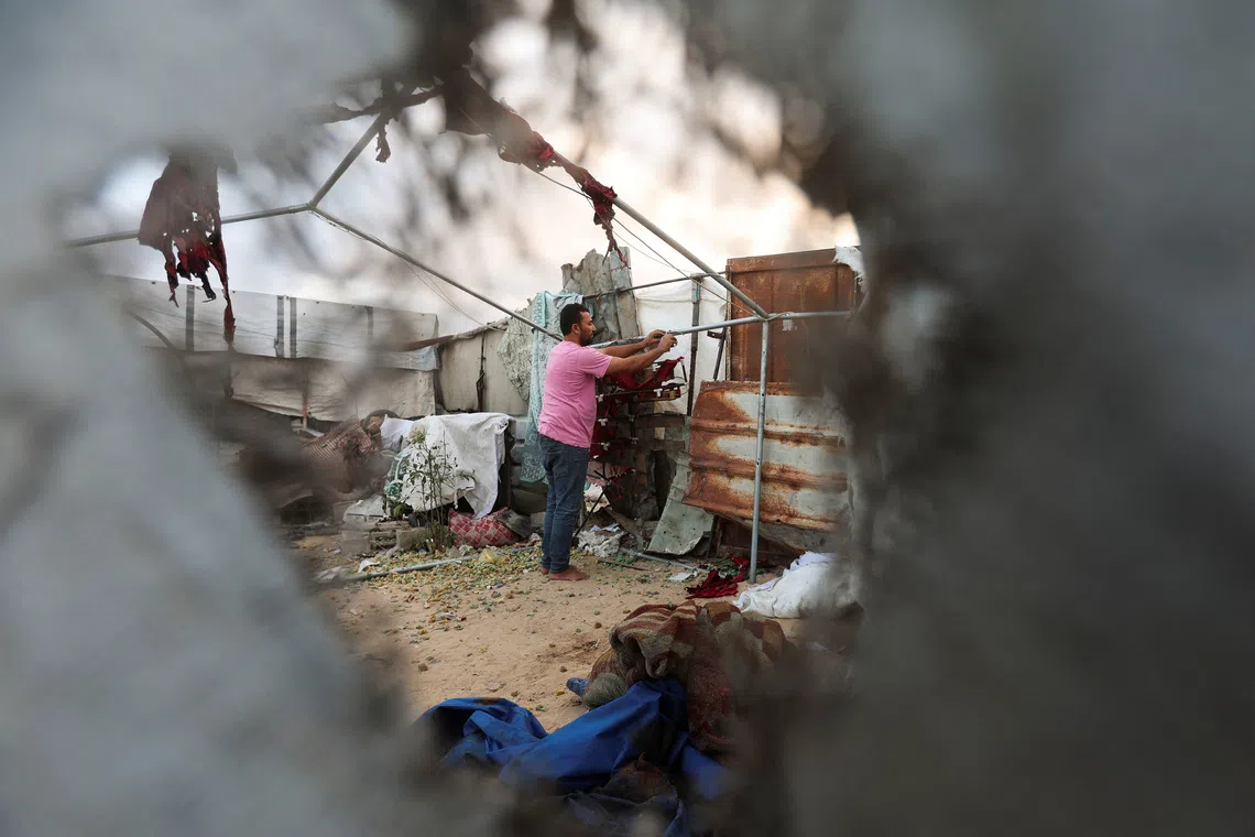 A Palestinian man inspects the site of an Israeli strike on a tent in Khan Younis, in the southern Gaza Strip, October 12, 2026. REUTERS/Ramadan Abed