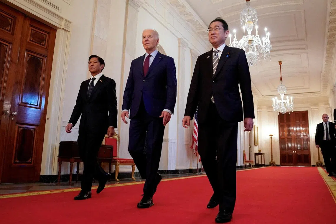 U.S. President Joe Biden escorts Philippines President Ferdinand Marcos Jr. and Japan Prime Minister Fumio Kishida to their trilateral summit at the White House in Washington, U.S., April 11, 2024.  REUTERS/Kevin Lamarque     TPX IMAGES OF THE DAY     