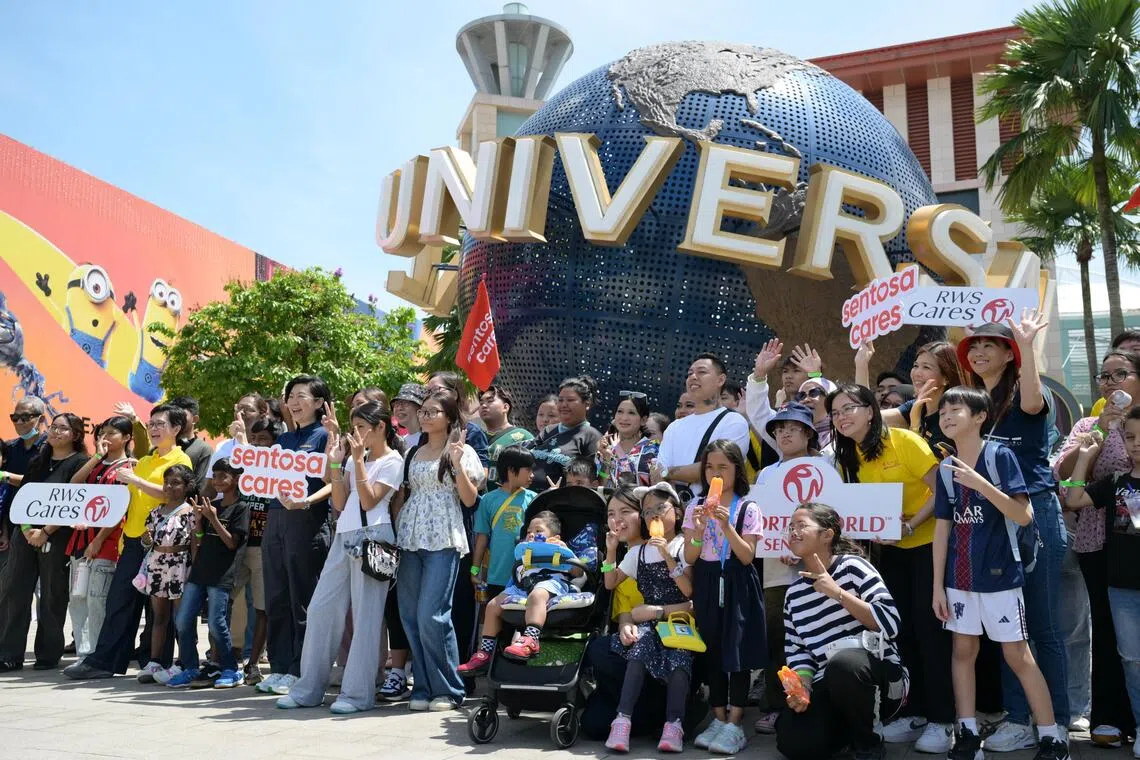 Some of the beneficiaries and their families from The Straits Times School Pocket Money Fund (STSPMF) together with volunteers from RWS and SDC at Universal Studios Singapore on Nov 29, 2025.