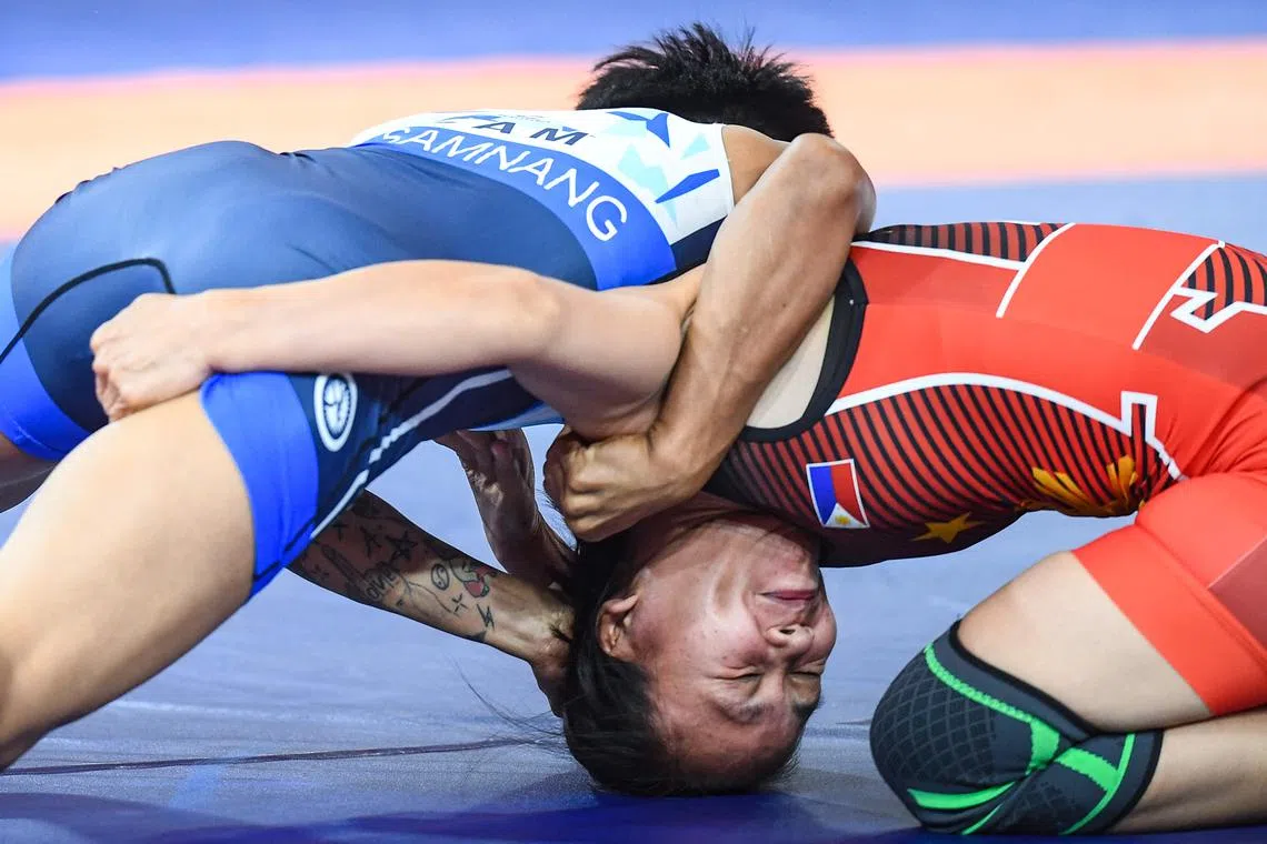 Philippines' Maribel Jambora-Angana (R) competes against Cambodia's Samnang Dit (L) in their women's -53kg wrestling round match during the 32nd Southeast Asian Games (SEA Games) in Phnom Penh on May 15.