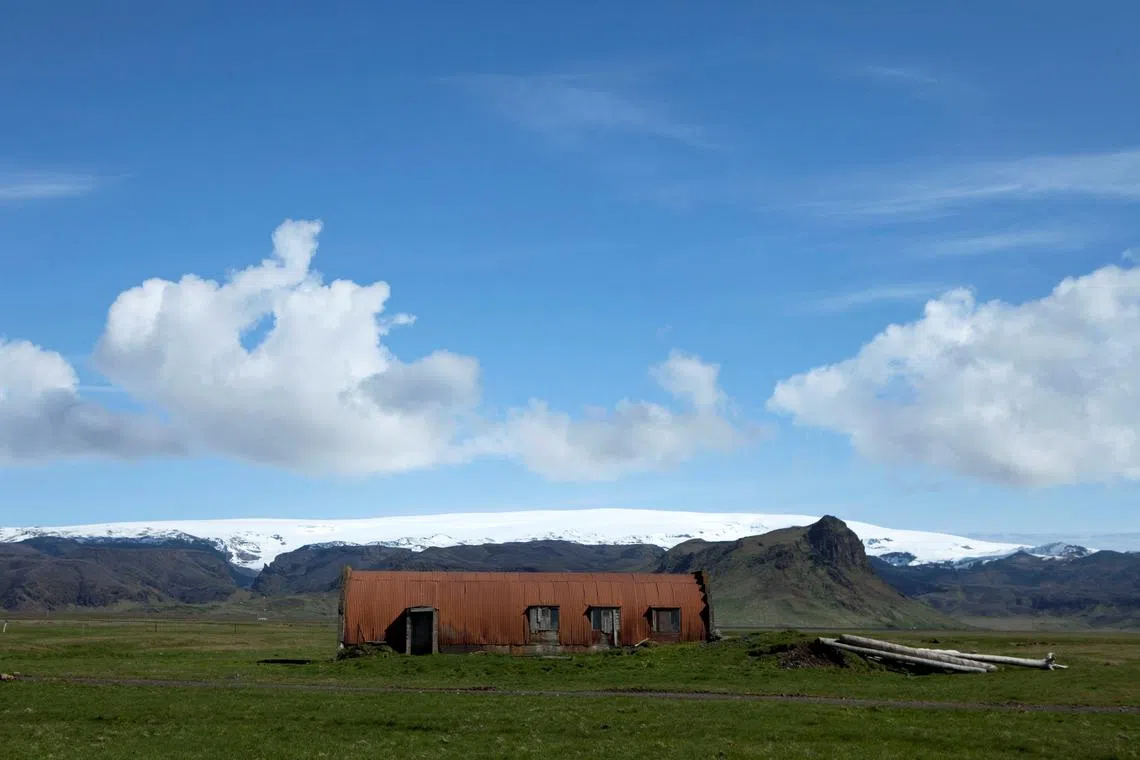 FILE PHOTO: A farm building stands in a field below the Myrdalsjokull glacier that covers the Katla volcano in Evindarholar, Iceland May 28, 2011. REUTERS/Lucas Jackson/File Photo