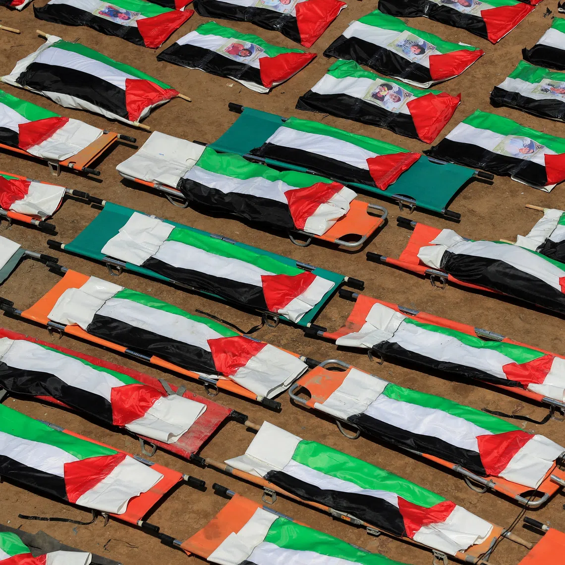 Bags containing the remains of Palestinians, draped in Palestinian flags, are lined up during the funeral of 112 members of the Hassayna and Abu Sharia clan, who were killed in an Israeli strike in 2023 and whose remains were recovered from beneath the rubble, according to Gaza's Civil Defense, in Gaza City, August 4, 2026. REUTERS/Dawoud Abu Alkas       TPX IMAGES OF THE DAY