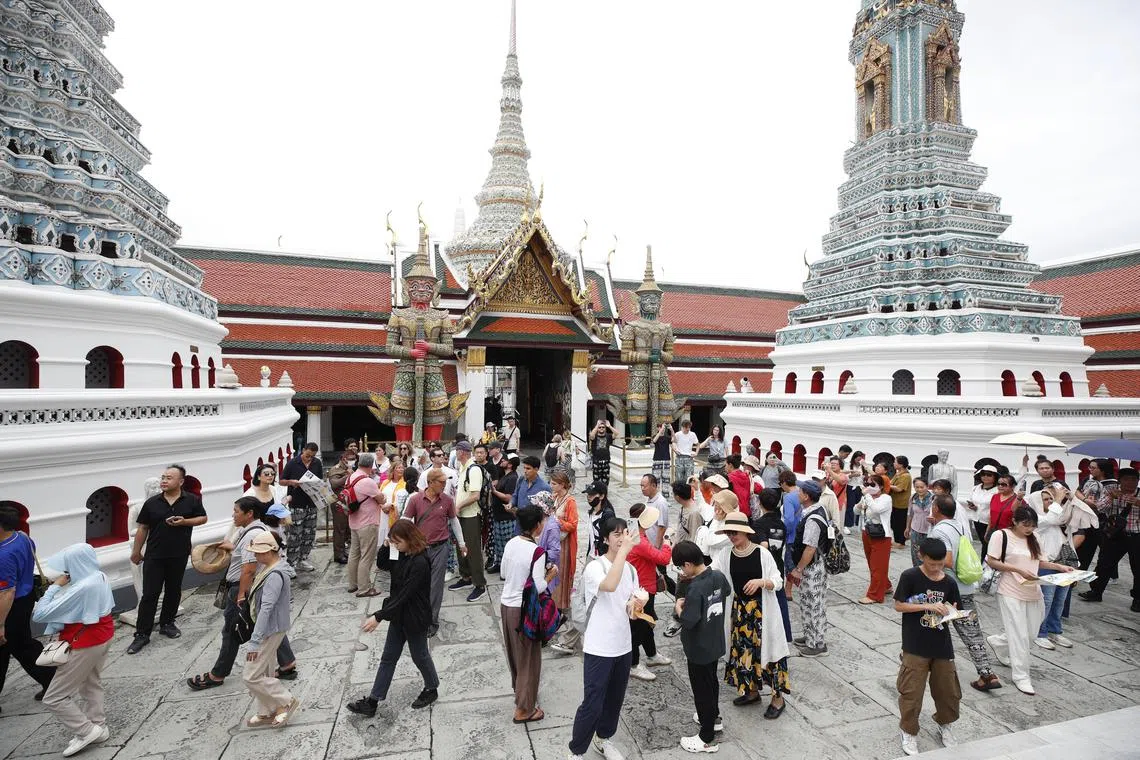 Foreign tourists visit the Temple of the Emerald Buddha at the Grand Palace complex in Bangkok, on July 15.