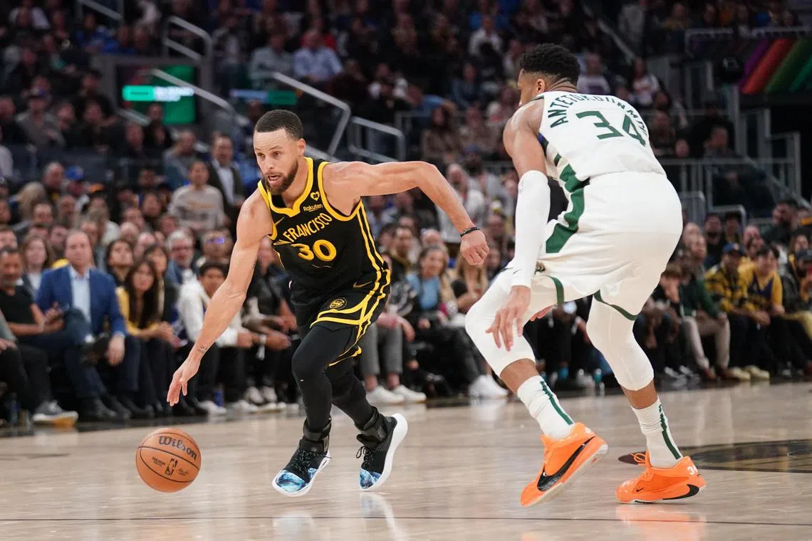 Golden State Warriors guard Stephen Curry dribbling past Milwaukee Bucks forward Giannis Antetokounmpo en route to a 125-90 NBA victory at Chase Centre on March 7.