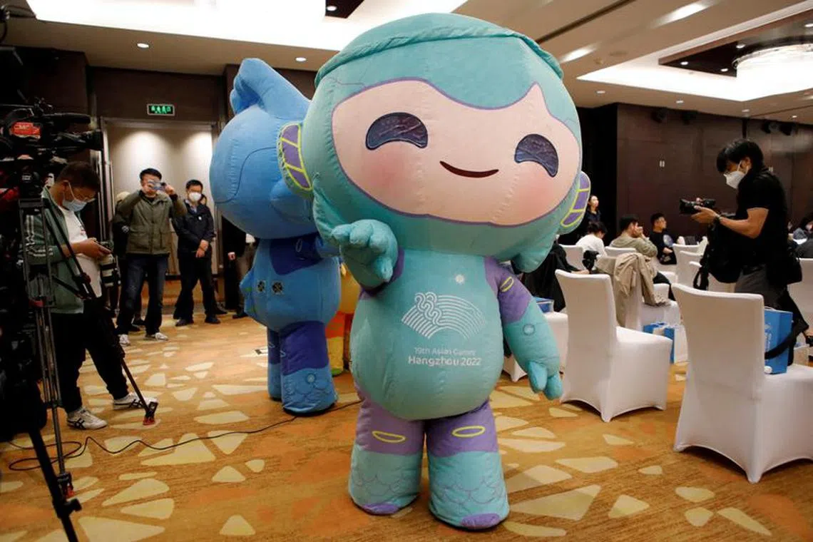 FILE PHOTO: A staff member dressed as Lianlian, one of the three mascots of the 19th Asian Games Hangzhou 2022, walks past journalists before a media briefing on the preparations for the Games, in Beijing, China April 27, 2023. REUTERS/Florence Lo/File Photo