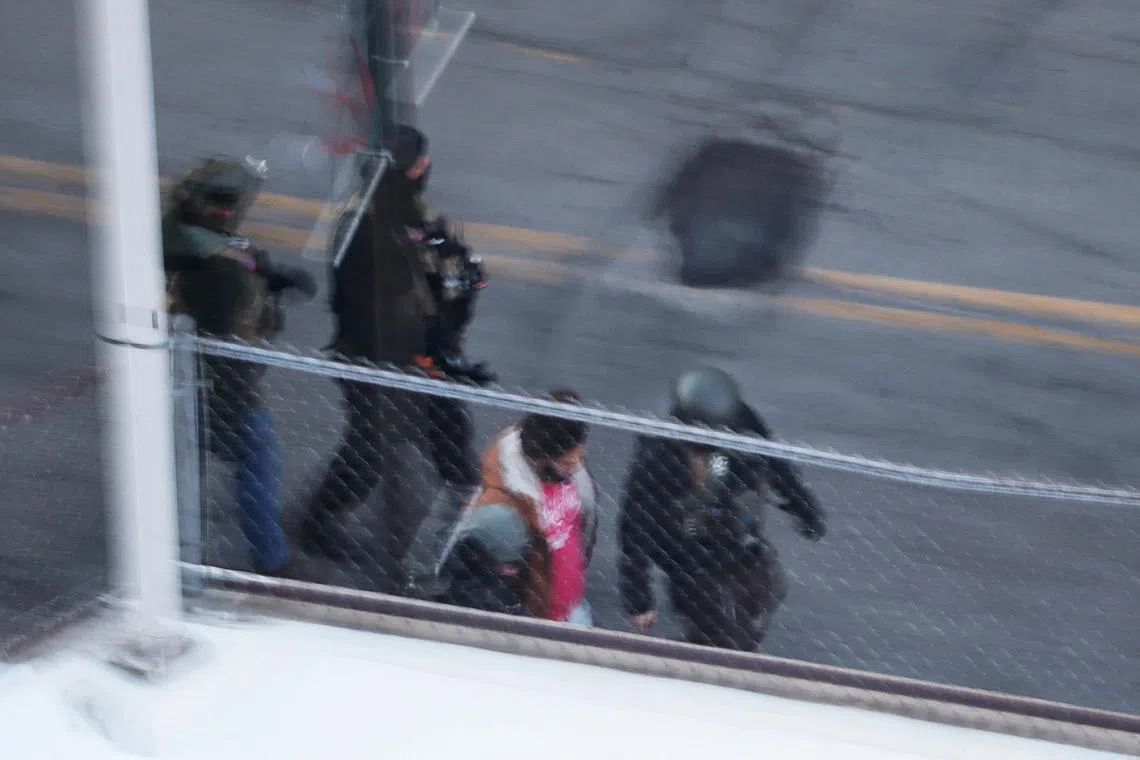 Federal immigration enforcement agents detain a person from an apartment building, days after a man identified as Alex Pretti was fatally shot by federal immigration agents trying to detain him, in Minneapolis, Minnesota, U.S., January 28, 2026.   REUTERS/Brian Snyder