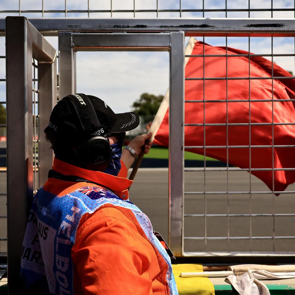 Formula One F1 - Australian Grand Prix - Albert Park Grand Prix Circuit, Melbourne, Australia - March 7, 2026 A race marshal waves a red flag after Mercedes' Kimi Antonelli crashes during the third practice session REUTERS/Mark Peterson
