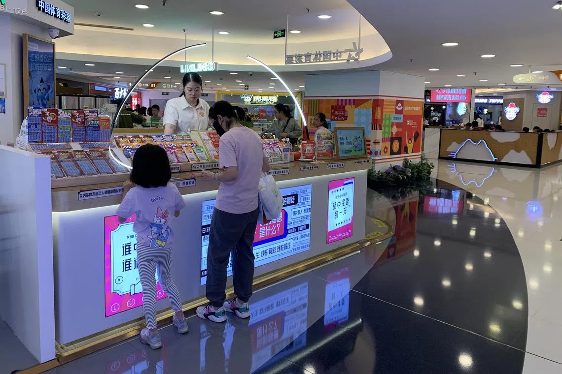 A lady examines the card she has just scratched at a Beijing lottery store, to check if she has won anything.