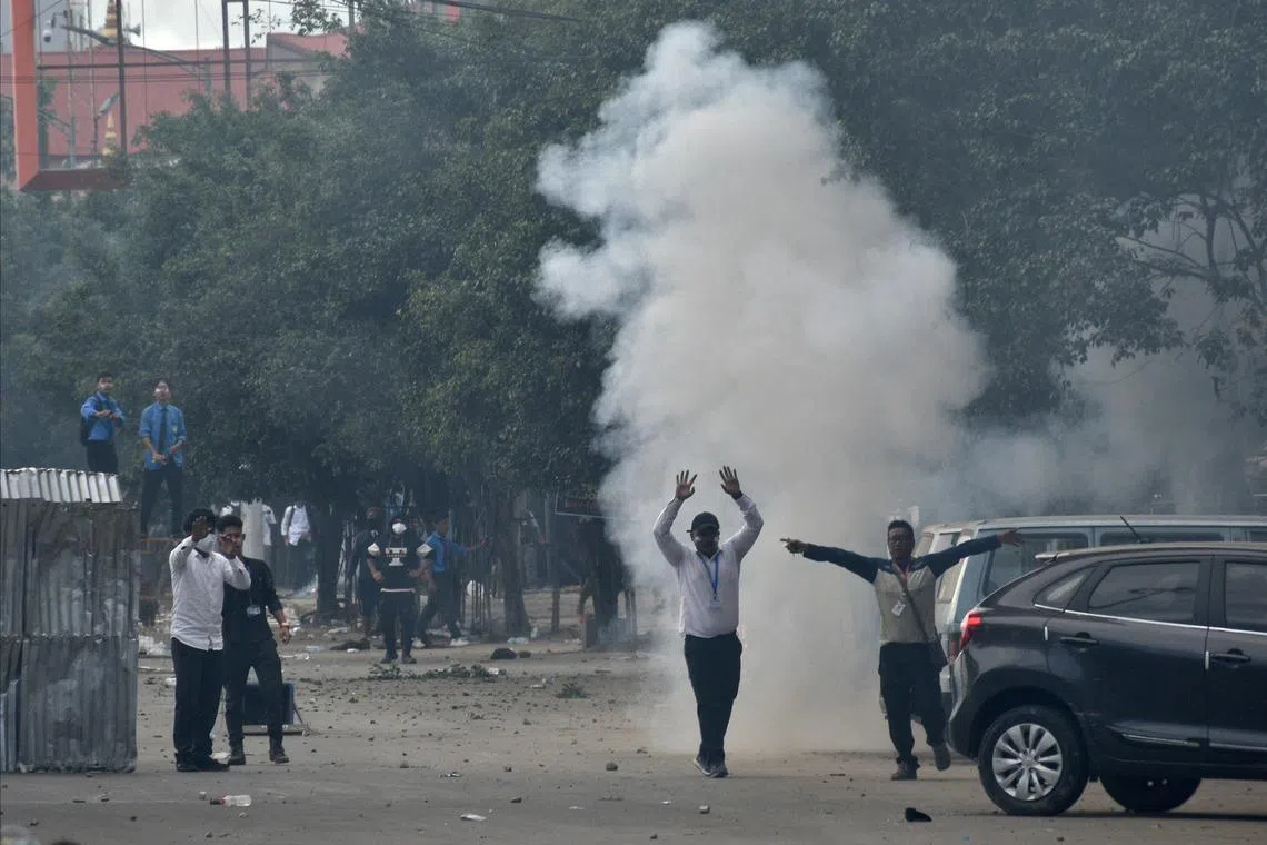 Demonstrators react as smoke billows from a tear gas shell fired by police to disperse the protesters during a protest march to demand an end to the latest spurt of ethnic violence, in Imphal, Manipur, India, September 10, 2024. REUTERS/Stringer/ File Photo