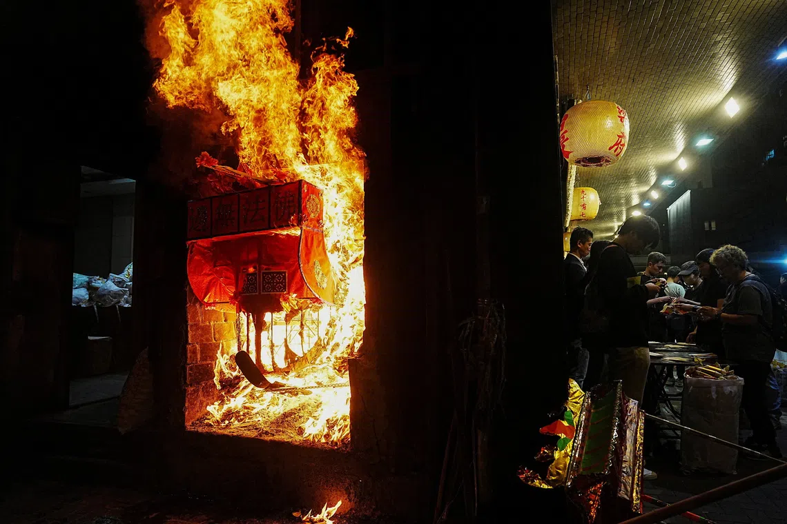 People burning offerings at Kowloon Funeral Parlour for victims of the deadly fire at the Wang Fuk Court housing complex in Tai Po, in Hong Kong, China, on Dec 2, 2025. 