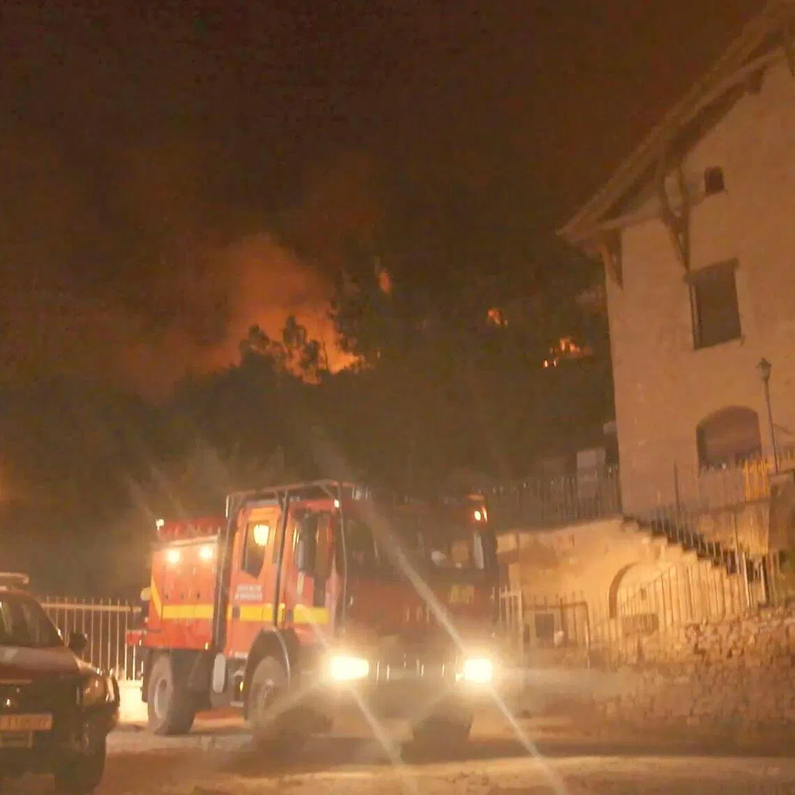 A video screengrab shows a firefighters’ vehicle with flames in the background, in a village near Penas de Riglos, in the Spanish southwestern province of Aragon.