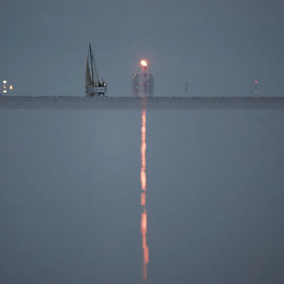 A yacht sails past a gas flare at Portovaya Bay on the coast of the Gulf of Finland in the Leningrad Region, Russia August 26, 2022. REUTERS/Stringer