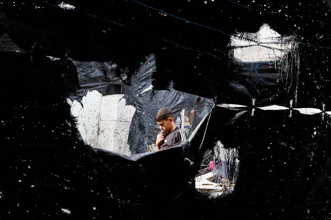 A boy walking at the site of a drone strike in Nur Shams refugee camp in Tulkarm in the Israeli-occupied West Bank, Aug 27, 2024. 