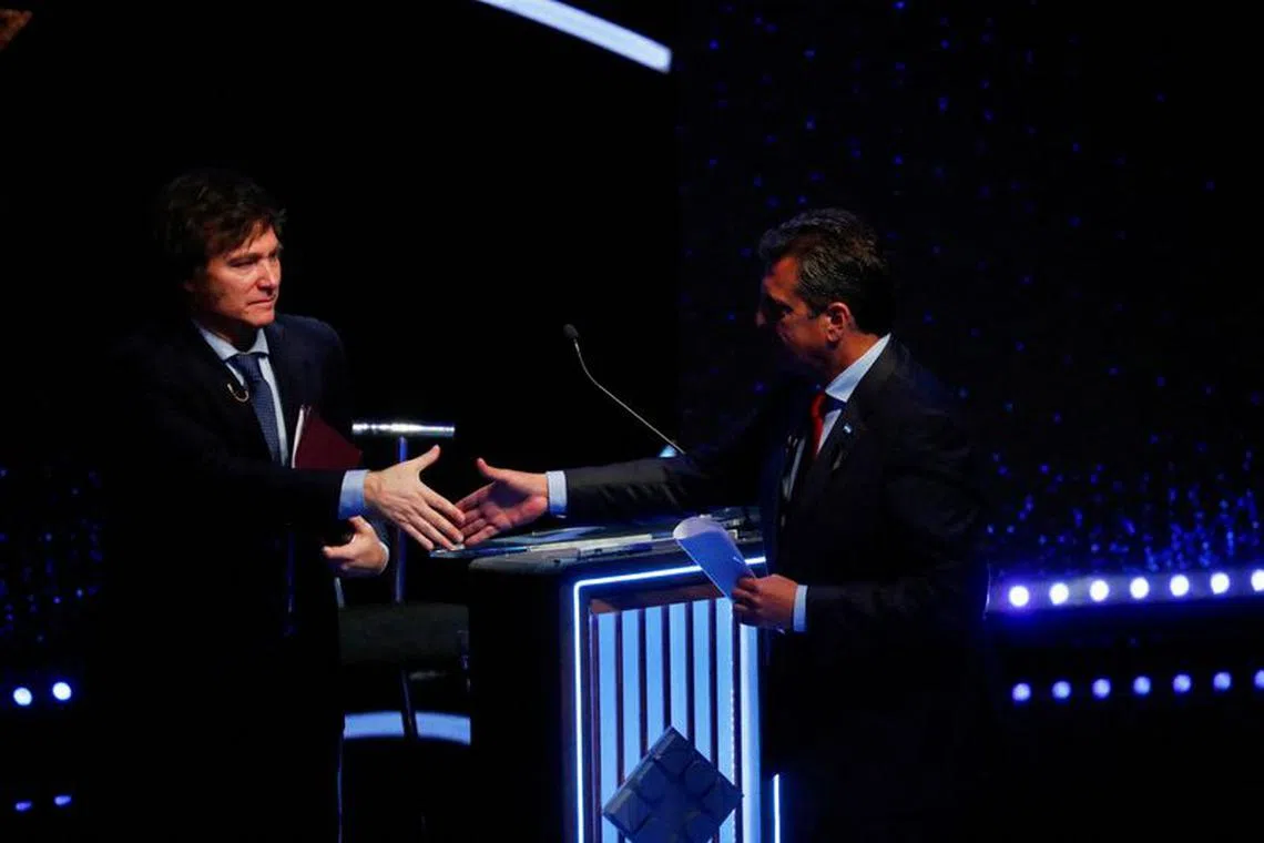 FILE PHOTO: Argentine Presidential candidates Sergio Massa and Javier Milei shake hands as they attend the presidential debate ahead of the October 22 general elections, at the University of Buenos Aires' Law School, Argentina October 8, 2023. REUTERS/Agustin Marcarian/Pool/File Photo