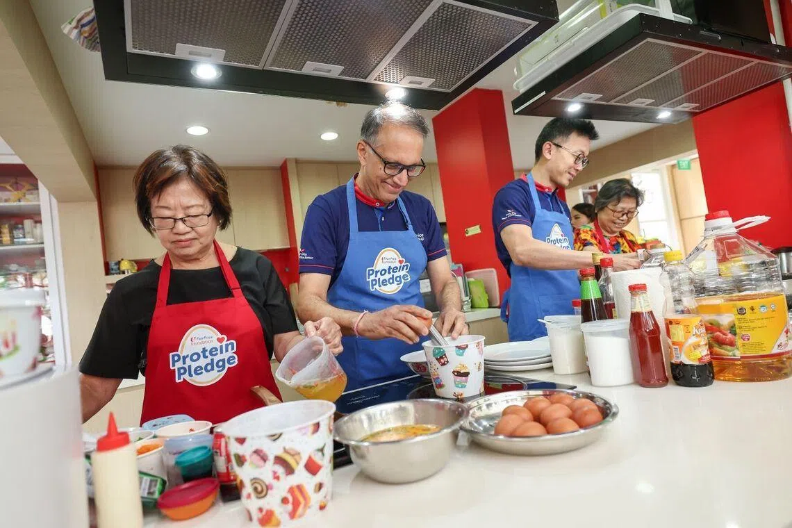 Mr Vipul Chawla group chief executive officer of FairPrice Group with Mr David Goh chief executive officer (Supermarket, Cheers, Unity) cooking with seniors at the launch of the Protein Pledge.