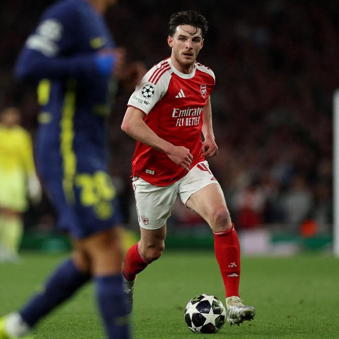 Arsenal's English midfielder Declan Rice runs with the ball during a Champions League match against Atletico Madrid.