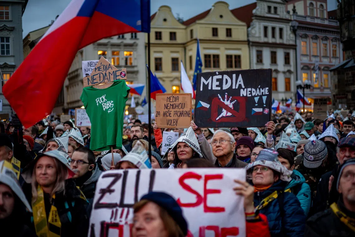 A woman holds a placard reading 'We won't give up the media' during the protest at Old Town Square in Prague, on Oct 25.